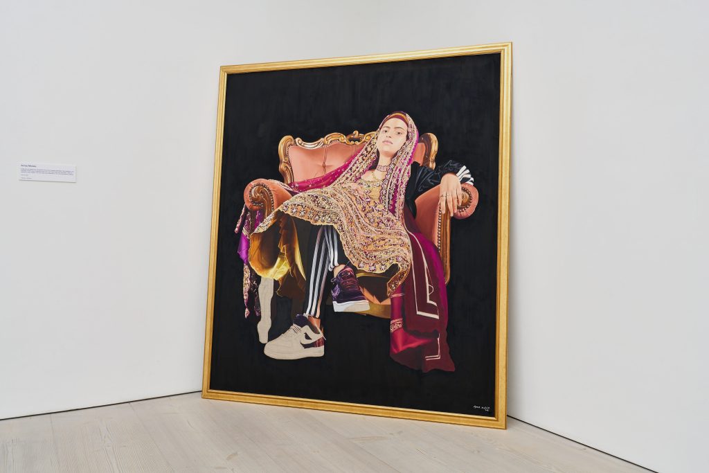 Contemporary oil painting by Azraa depicting a young woman reclining wearing traditional South Asian dress layered with tracksuit and trainers.