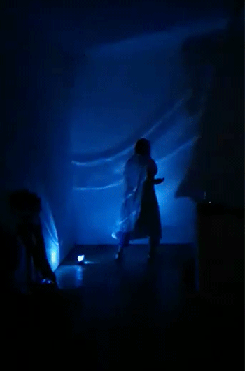 An animation that flicks through shadowy images of a figure in a hospital gown moving in a flashing blue light.